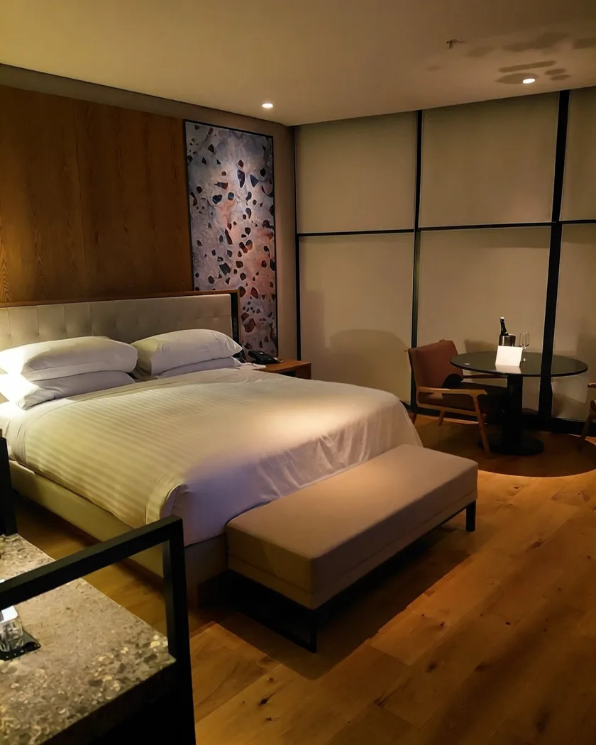 A suite at The Ritz-Carlton in Perth, timber panelling, a chilled bottle on the table by the window.